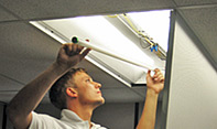 Technician changing a flourescent light.